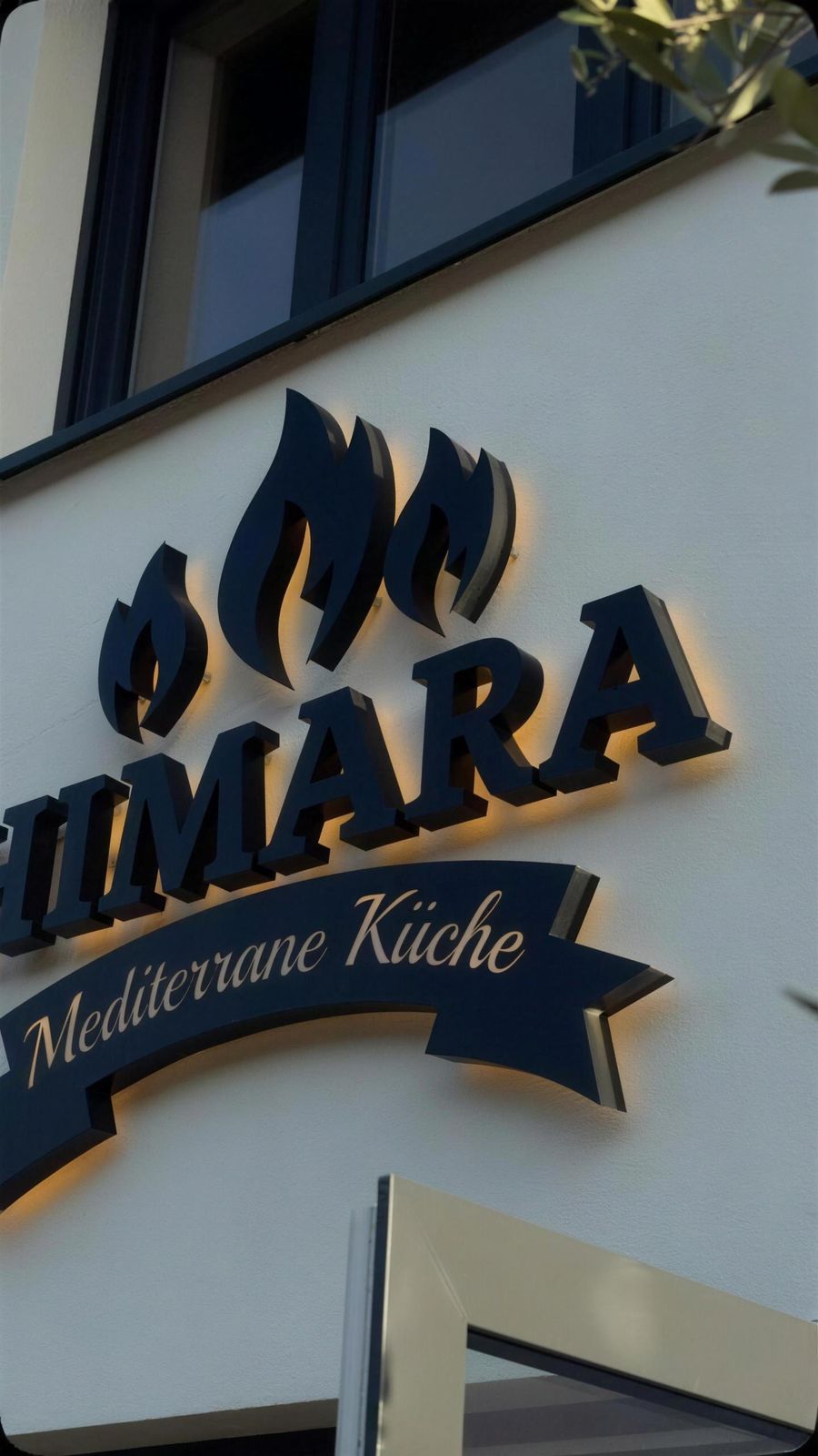 Beleuchteter Himara-Schriftzug an der Fassade